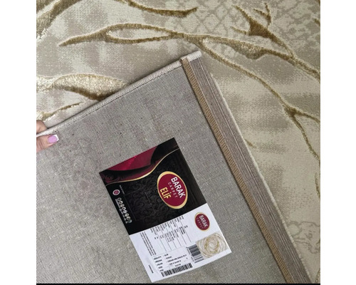 Prim-plan cu un covor cu model floral și eticheta mărcii Barak Carpet Elif.