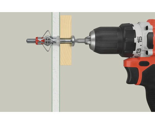 O mașină de găurit înșurubează un diblu basculant într-un perete de gips-carton.