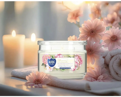 Lumânare parfumată în pahar cu motiv floral, înconjurată de decorațiuni