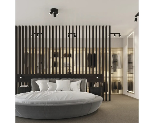 Dormitor cu pat rotund, lambriu din lemn închis la culoare și dressing