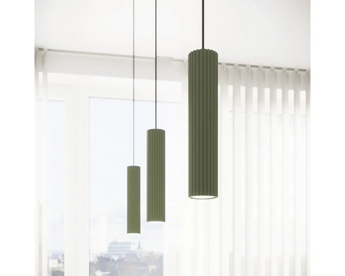 Trei lămpi suspendate verzi cu o suprafață canelată atârnă în fața unei ferestre.