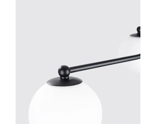 Prim-plan cu o lampă cu abajur sferic și cadru negru