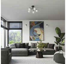 Cameră de zi cu canapea gri, tablou abstract și plantă de apartament pentru o atmosferă luminoasă și organizată.