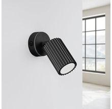 Lampa de perete neagră cu spot reglabil și întrerupător încorporat pe un perete.