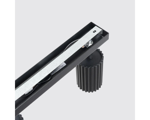 Vedere interioară a unui corp de iluminat negru pe șină cu suport argintiu