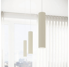 Trei lămpi suspendate cilindrice cu suprafață canelată atârnă în fața unei ferestre