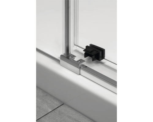 Detaliu al unei cabine de duș cu perete de sticlă și cadru metalic