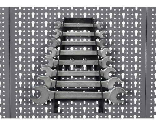 Un set de chei combinate, aranjate într-un suport, montat pe un perete de scule.