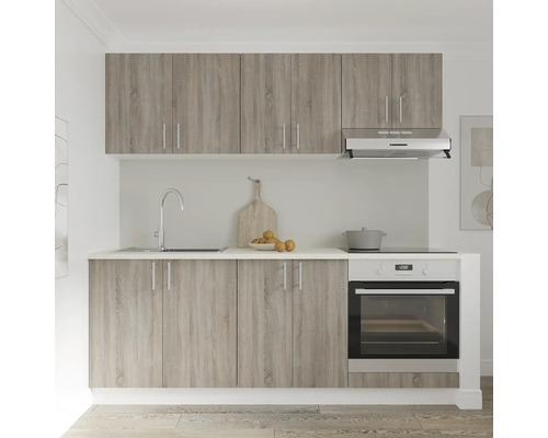 Bucătărie cu chiuvetă, aragaz, cuptor, hotă și dulapuri cu aspect de lemn.