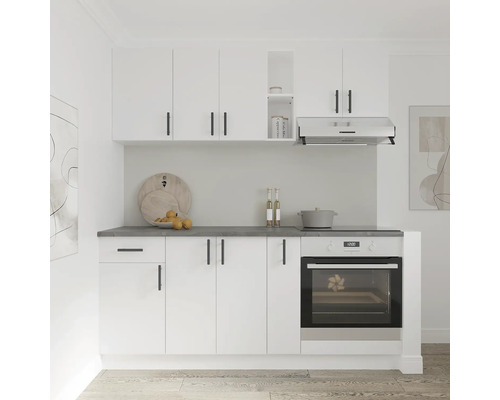 Bucătărie compactă cu dulapuri albe, blat de lucru închis la culoare și cuptor încorporat