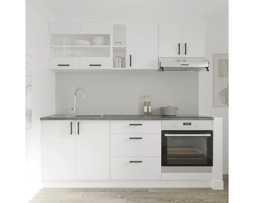 Bucătărie luminoasă cu chiuvetă, aragaz, hotă și dulapuri albe