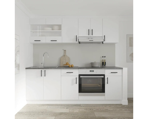 Bucătărie albă cu chiuvetă, aragaz și dulapuri suspendate