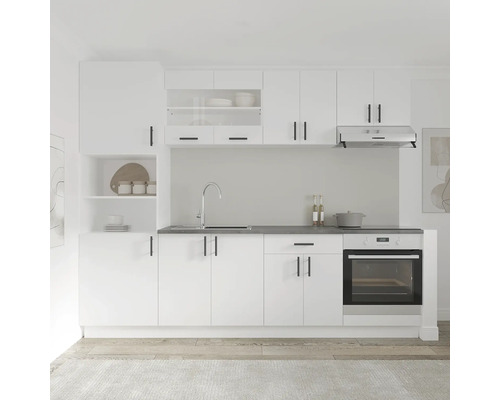 Bucătărie luminoasă cu dulapuri albe, chiuvetă și cuptor.