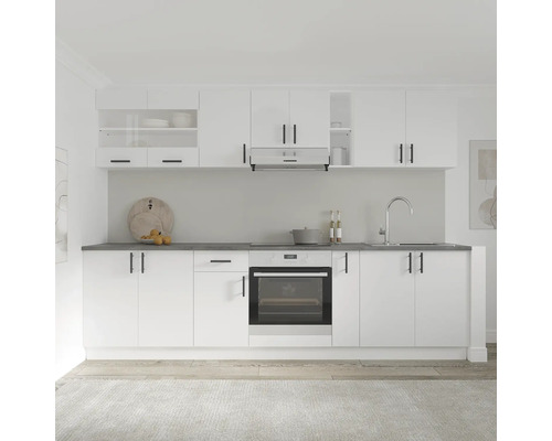 Bucătărie luminoasă cu dulapuri albe, hotă și cuptor încorporat.