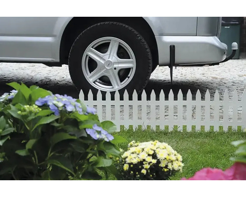 Gard alb cu mașină și flori