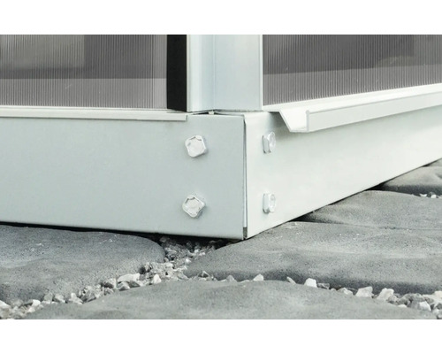 Imagine detaliată a unei fundații metalice de seră cu șuruburi pe o podea de piatră