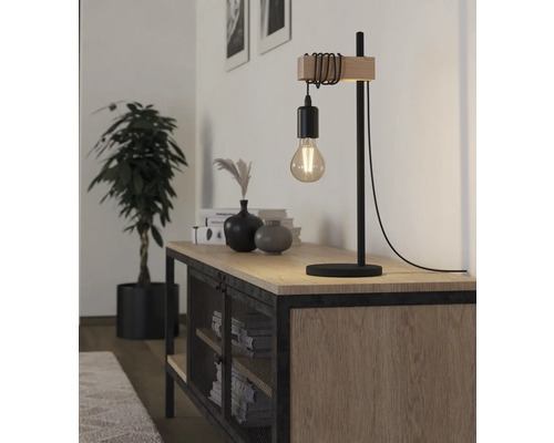 Lampă de masă decorativă din lemn și metal pe un bufet