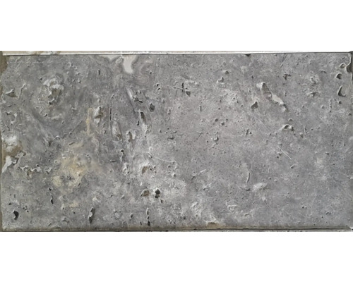 Placă de travertin gri cu suprafață neregulată.