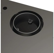 Prim-plan cu o inserție metalică rotundă într-un blat de masă