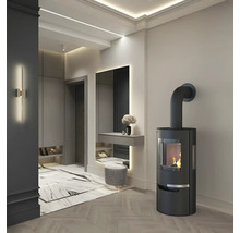 Interior elegant cu sobă, oglindă și taburet într-o cameră luminoasă.