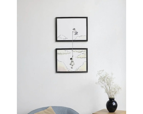 Două ilustrații înrămate pe perete cu motivul unui băiat care aruncă o funie unei fete pentru a urca în cer.