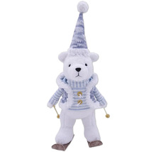 Urs polar decorativ cu căciulă, fular și schiuri ca decorațiune de Crăciun.