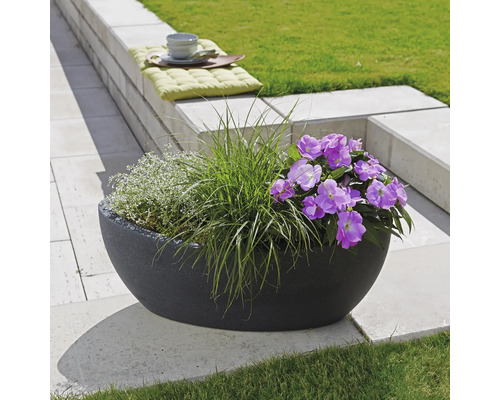 Jardinieră decorativă cu flori și ierburi în grădină