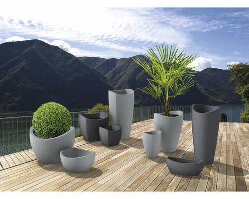 Diverse jardiniere gri cu plante pe o terasă de lemn