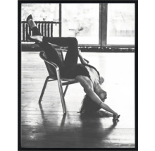 Fotografie alb-negru a unei femei așezate cu susul în jos pe un scaun