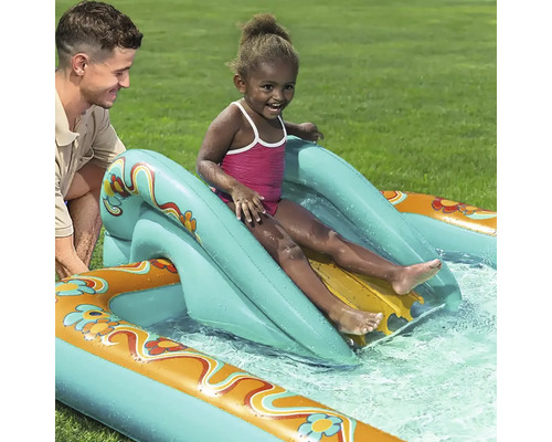 Copil alunecând pe un tobogan gonflabil în piscină