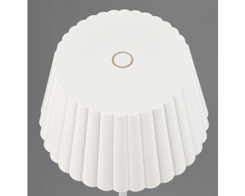 Prim-plan cu o lampă de podea albă cu abajur plisat