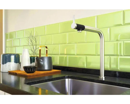 Scenă de bucătărie cu chiuvetă, robinet și decorațiuni pe un blat în fața unui perete cu faianță