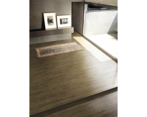 Cameră luminoasă cu podea din lemn, covor și două imagini înrămate pe perete