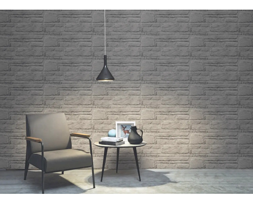 Cameră de zi cu tapet cu aspect de piatră, fotoliu, masă și lampă suspendată