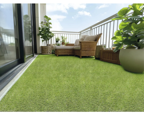Balcon cu gazon artificial, mobilier din ratan și plante pentru o atmosferă primitoare