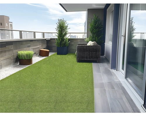 Balcon cu gazon artificial, jardiniere, scaune și pietre decorative pentru o atmosferă primitoare în aer liber.