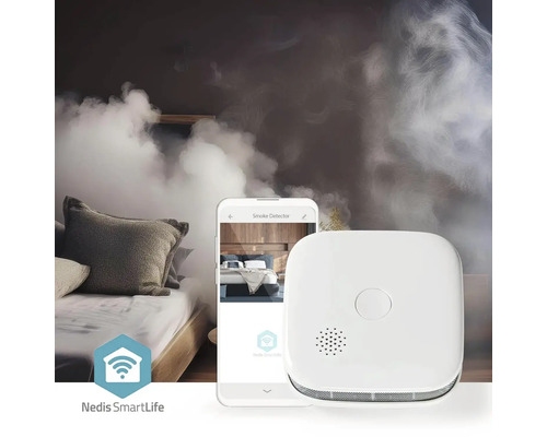 Detector de fum lângă smartphone într-un dormitor cu fum