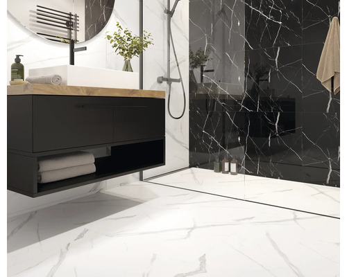 Baie modernă cu lavoar negru, lavoar alb așezat pe blat și plăci de faianță cu aspect de marmură