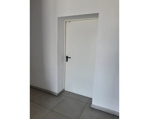 Ușă interioară albă cu mâner negru într-o cameră