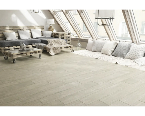 Living luminos cu podea din lemn, mobilier din paleți și ferestre de mansardă.