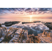 Peisaj de coastă stâncos la răsărit cu ape calme