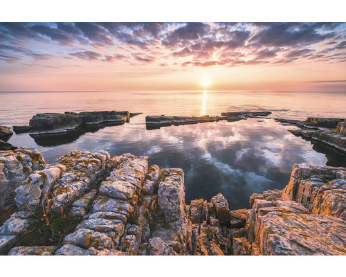 Peisaj de coastă stâncos la răsărit cu ape calme