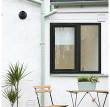 Fereastră cu ramă neagră pe un perete alb