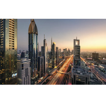 Imagine panoramică a orizontului orașului Dubai cu zgârie-nori iluminați și trafic rutier la amurg.