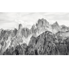 Fotografie alb-negru a unui peisaj montan cu formațiuni stâncoase accidentate și un cer înnorat