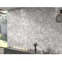 Decor de perete cu plăci de format mare cu aspect de piatră deasupra unui șemineu modern.