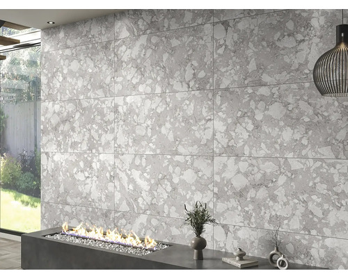 Decor de perete cu plăci de format mare cu aspect de piatră deasupra unui șemineu modern.