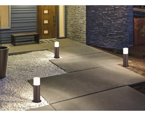 Alee luminată cu lumini exterioare în fața unei case