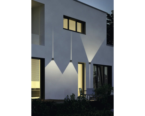 Fațadă de casă cu trei aplice de perete exterioare care emit lumină direcționată în jos.