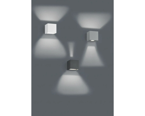 Trei lămpi de perete cubice din metal pe un perete